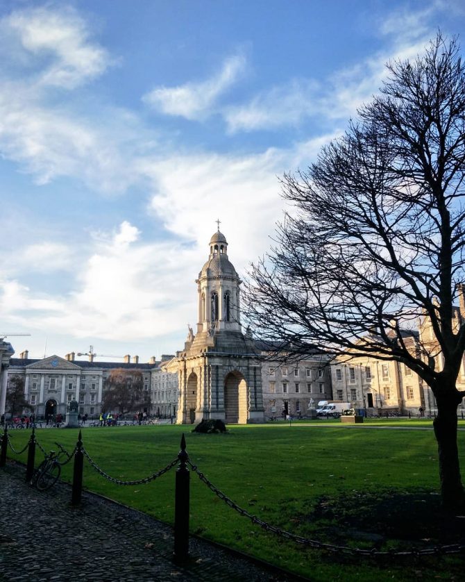 Green grass with a railing overlooking Trinity College