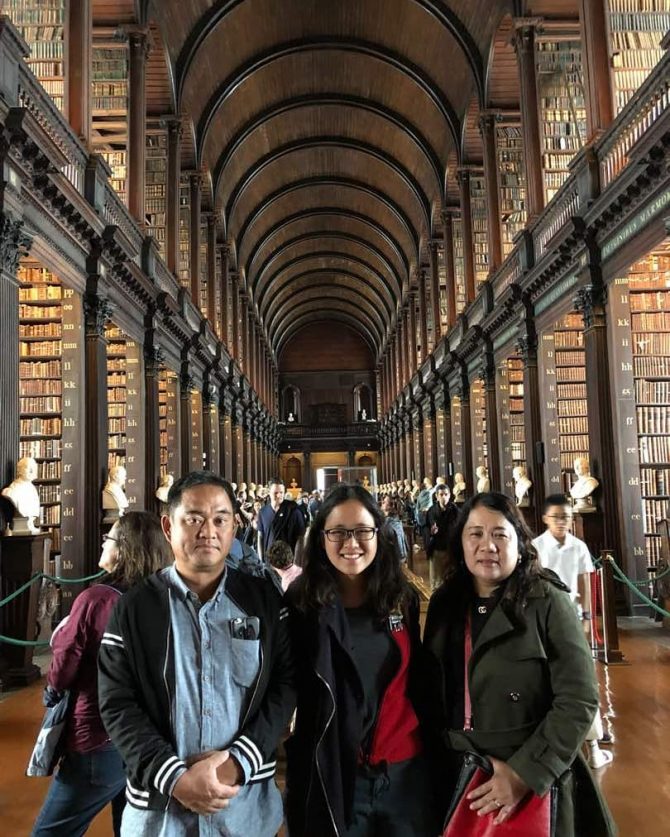Roof of Library in Trinity College Dublin, three smiling visitors in the foreground