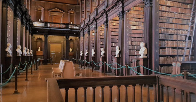 Shelves of books and busts in TCD Library
