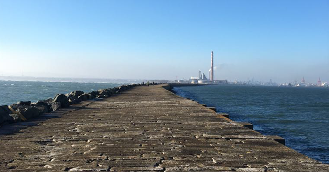 a long cobbled pier leading to two tall chimneys