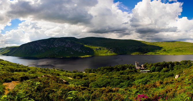 A scene of rolling green hills and a lake