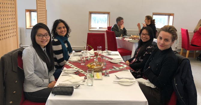 Four women sit a table having lunch