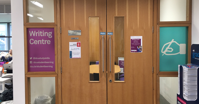 Closed wooden doors and a sign that reads "Writing Centre"