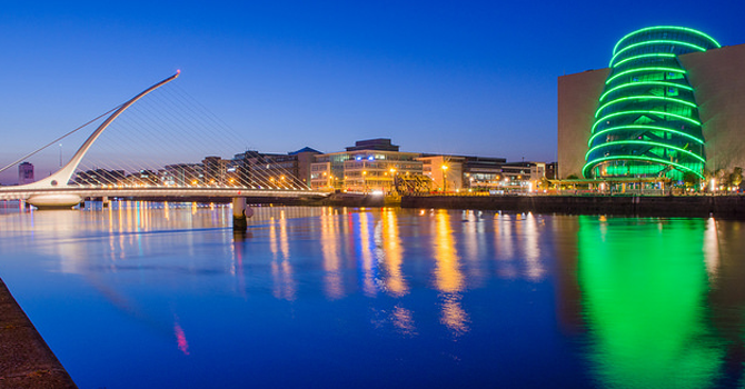 The lit up buildings of the silicon docks reflected in a body of water