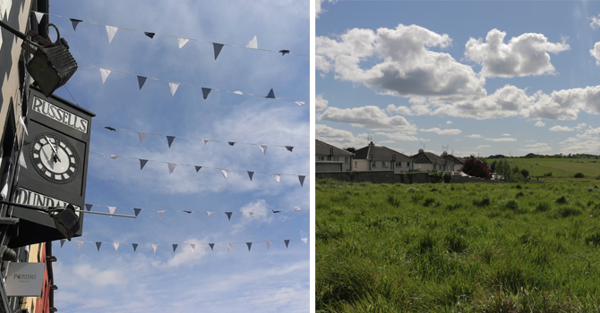 a view of a clear sky with bunting in the foreground and a lush green field on a sunny day