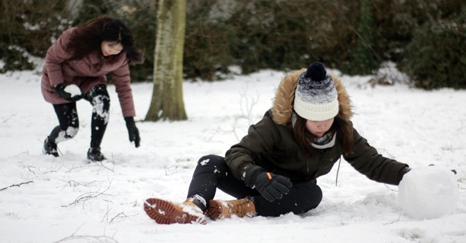 Two students playing in the snow