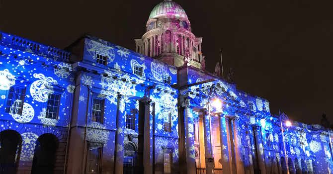 A building lit up with projected patters in blue and white