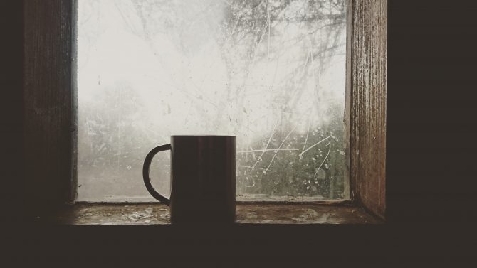 Coffee mug in dark room by a window