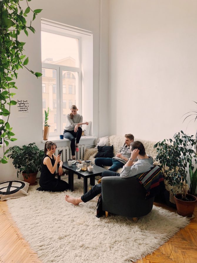 group of students gathered on a sofa in a white room 