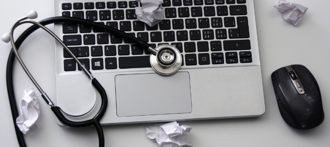 stethoscope on top of a laptop