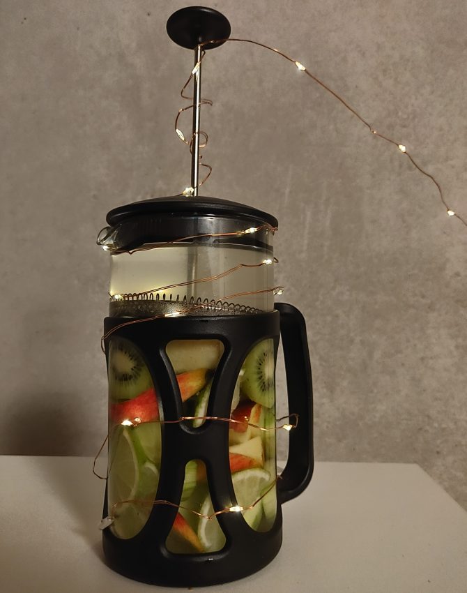 Chopped fruits and water inside a french press