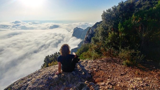 woman sitting on a mountain top meditating