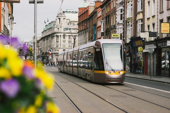 Luas tram travelling past shop fronts 