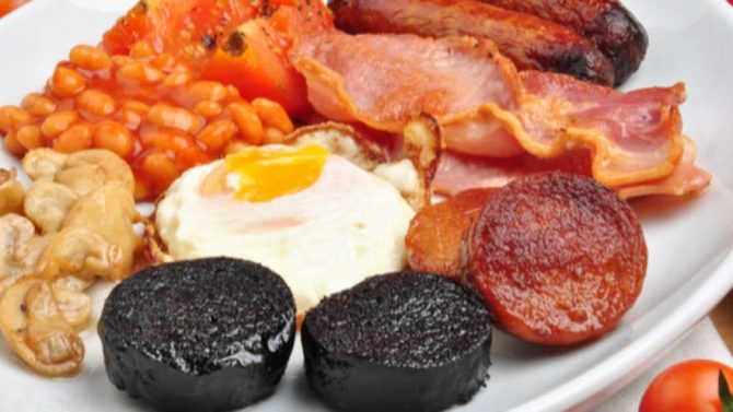 eggs, bacon, sausages, mushrooms and black and white pudding on a plate