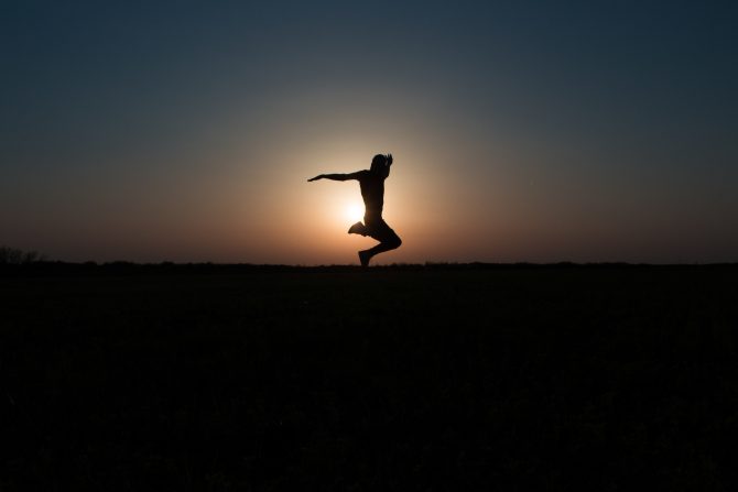 silhouette of a man against sunset leaping skyward 