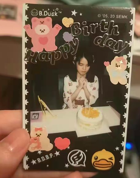 A picture of a polaroid image of a girl on her birthday with a birthday cake